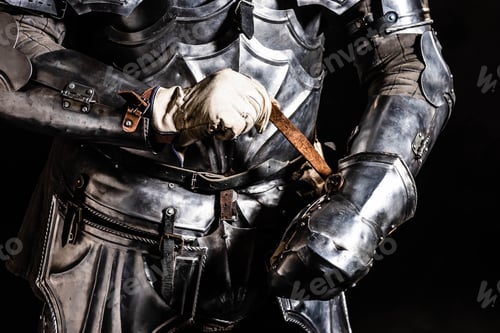 Preview: cropped view of knight in armor holding sword isolated on black