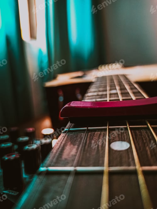 Preview: Closeup shot of a guitar with a sound mixer on blurred background