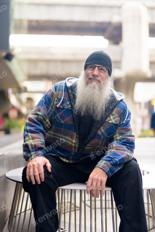 Preview: Mature handsome bearded man thinking in the city streets