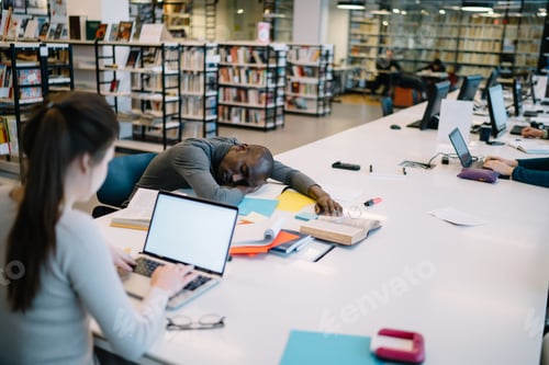 Preview: Ethnic man sleeping with open book in library