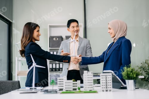 Preview: Group of diverse multiethnic businesspeople standing neare table looking at model