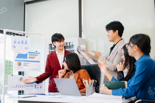 Preview: Group of diverse businesspeople using a laptop and tablet in office.