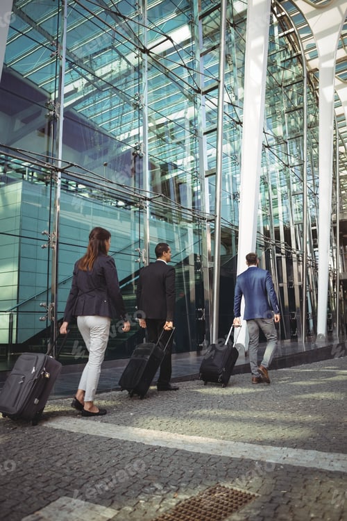 Preview: Business executives walking with suitcase outside platform