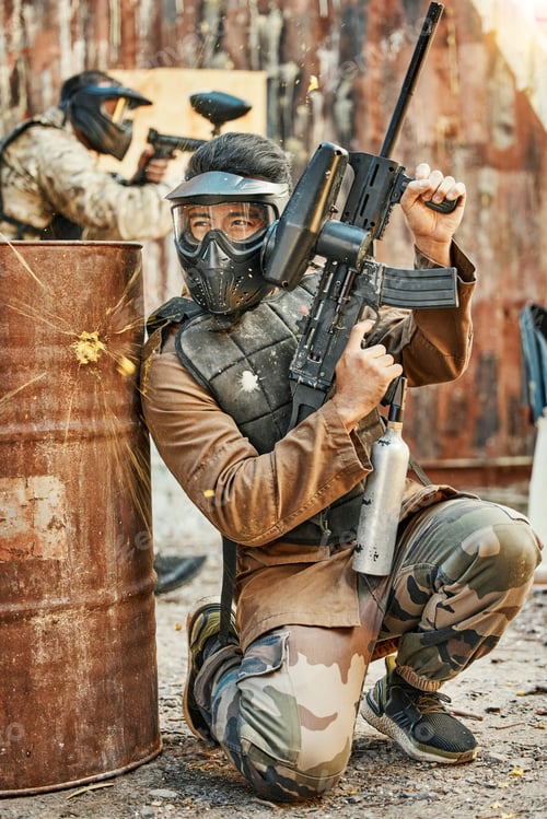 Preview: Paintball, soldier and man with gun for tournament, competition and battle in arena. Extreme sports