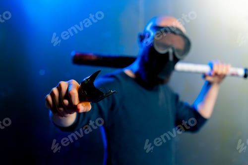 Preview: male robber in mask holding broken bottle and baseball bat in hand threats attack robbery
