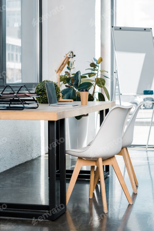 Preview: laptop and coffee in paper cup on wooden table in business office