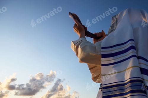 Preview: Jewish man blowing the Shofar horn of Rosh Hashanah - New Year. Shofar at Sunset