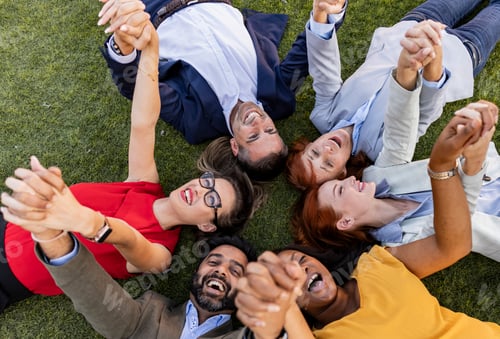 Preview: employees in a circle lying down shaking hands