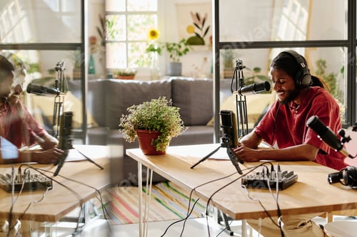 Preview: Young smiling man in headphones looking through his plan of discussion