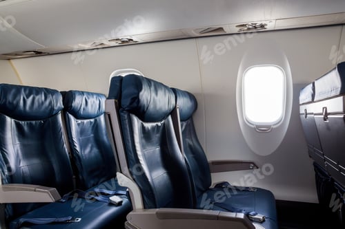 Preview: Armchairs in passenger cabin, with aircraft seats and window.