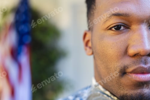 Preview: Focused african american male soldier face close up outside home with usa flag, copy space