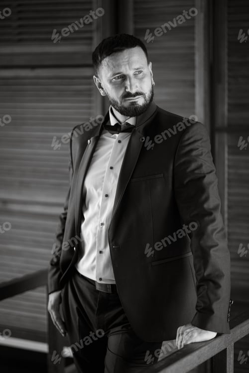 Preview: portrait of a groom with a beard in a blue suit