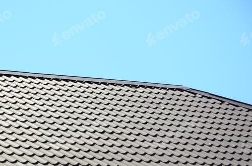 Preview: A fragment of a roof from a metal tile of dark red color. Quality Roofing