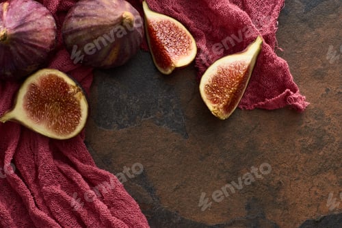 Preview: Top View of Whole And Cut Delicious Figs on Rustic Red Cloth on Stone Background