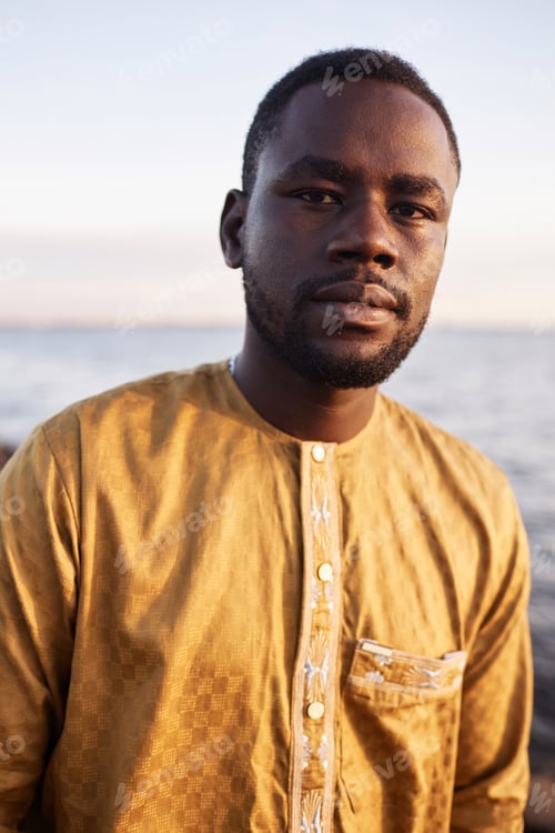 Preview: Black man looking at camera outdoors in nature