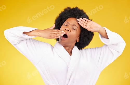 Preview: Yawn, morning and wake up with a black woman in studio on a yellow background wearing a bathrobe. R