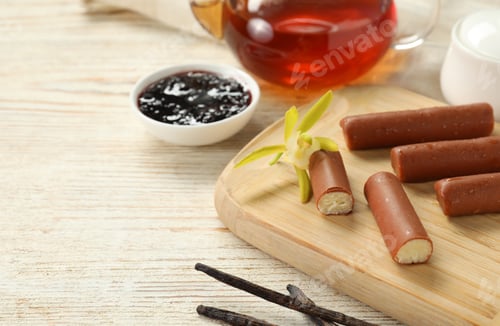 Preview: Glazed curd cheese bars, vanilla pods and tea on white wooden table, closeup. Space for text