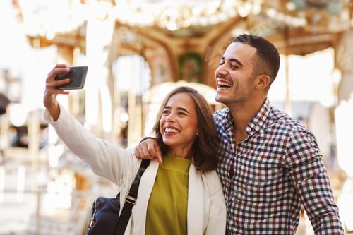 Preview: Young happy couple taking selfies in city