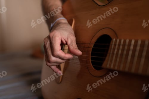 Preview: male hands elderly senior man holding playing classical guitar at home. guitarist play amateur music
