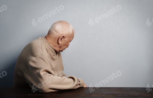 Preview: Back view on a turning back senior man sitting at the table