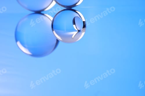 Preview: Transparent glass balls on blue background. Space for text