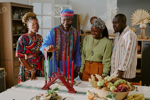 Preview: Group of Black Adults Celebrating Kwanzaa Lighting Kinara Candles Together