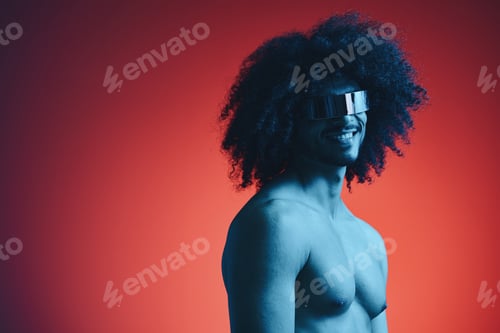 Preview: Portrait of fashion man with curly hair on red background with stylish glasses, multinational
