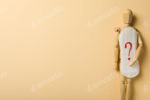 Preview: Menstrual cycle concept, wooden figurine of a man holding a pad