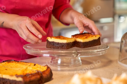 Preview: Crop person putting pieces of cake on glass dish