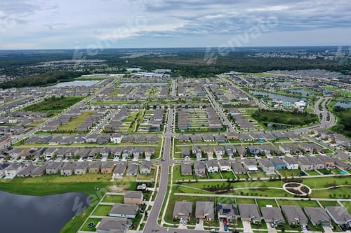 Preview: Aerial view of a suburb in Austin, Texas with trees and a cloudy sky in the background.