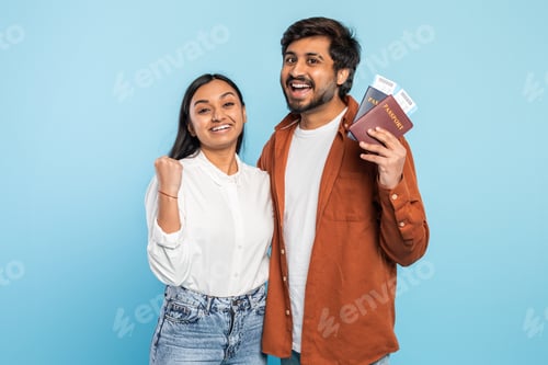 Preview: Excited couple with passports looking hopeful on blue