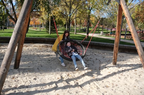Preview: woman with her child having fun at the playground