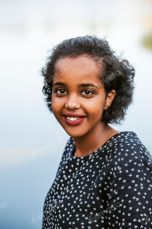 Preview: Portrait of happy young woman at lakeshore