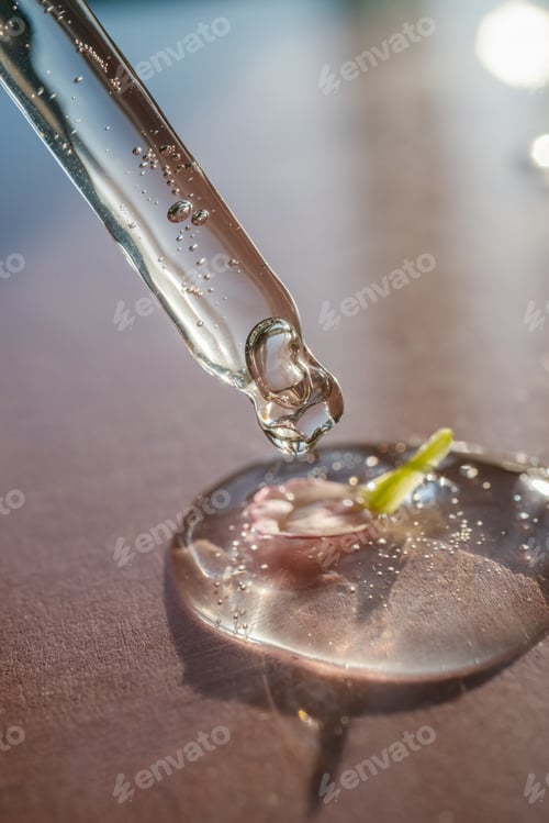 Preview: Pipette with cosmetic product and flower on the pink background