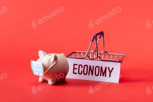 Preview: piggy bank in small medical mask near toy shopping basket and card with economy lettering on red