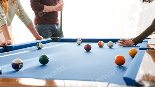 Preview: Unrecognizable friends playing pool in game room on weekend