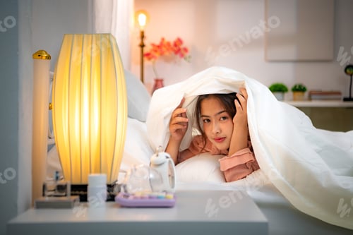 Preview: Asian young woman on the bed in the bedroom trying to wake up and prepare for work