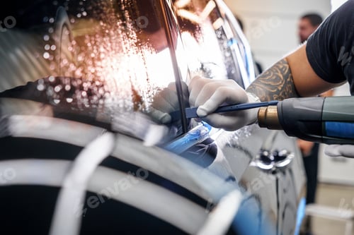 Preview: Sticker of a protective film on the headlight of a car in a car detailing studio