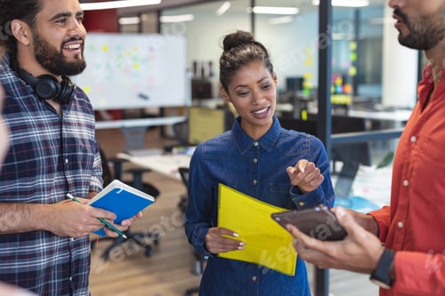 Preview: Diverse group of creative colleagues talking at casual meeting
