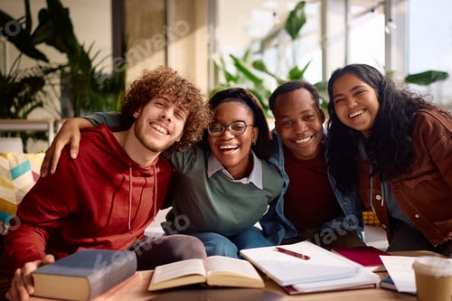 Preview: Cheerful group of university students having fun while learning together and looking at camera.