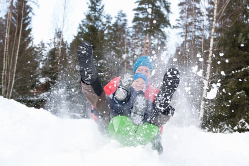 Preview: Man and son on speeding toboggan in snow covered forest