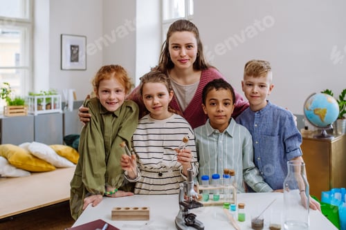 Preview: Portrait of young teacher with pupils during science education.