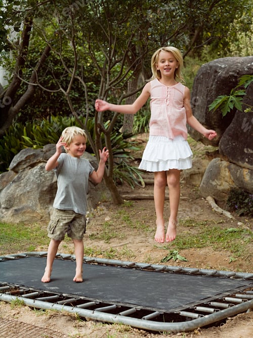 Preview: Brother and sister bouncing on trampoline