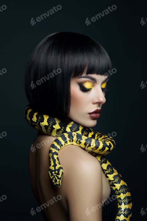 Vista previa: Bella mujer, corte de pelo corto, pitón, serpiente amarilla en el cuello. Una serpiente amarilla en los hombros