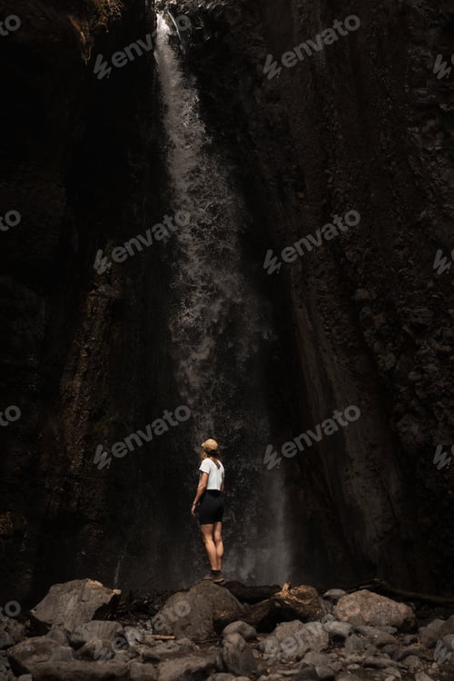 Preview: Tourist admiring majestic waterfall during mount meru trekking in tanzania, africa