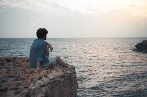 Preview: Charming Dreamer. Full Length Back View Of Pensive Stylish Bearded Male Is Sitting On The Edge Of