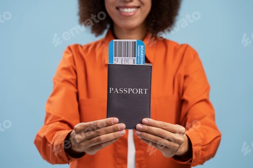 Preview: Smiling African American woman tourist holding passport with fly ticket isolated on blue background