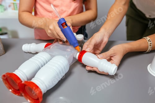 Preview: Student and teacher making recycled toy robot with hot melt glue gun