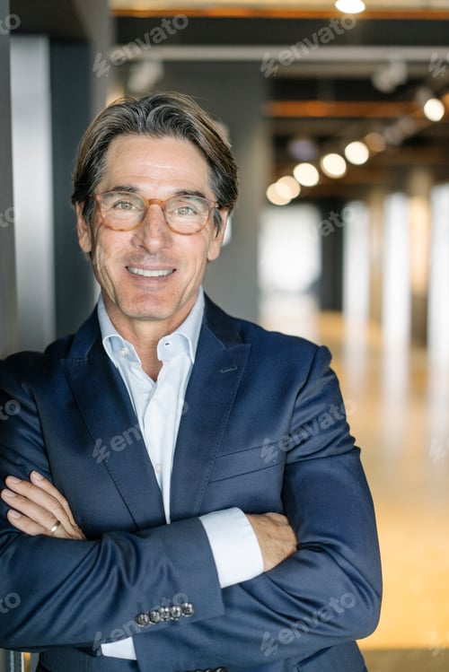 Preview: Portrait of smiling businessman wearing glasses in office