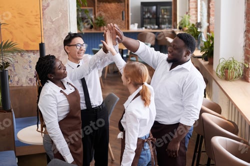 Preview: Group Of Cheerful Waiters Doing High Five